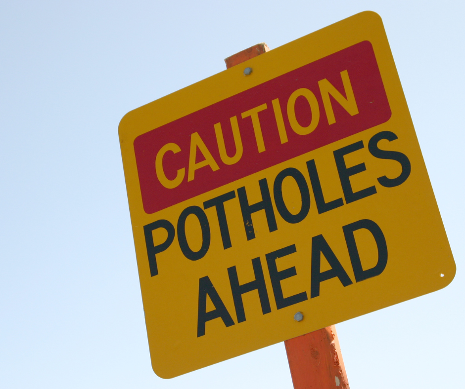 caution sign on damaged pavement